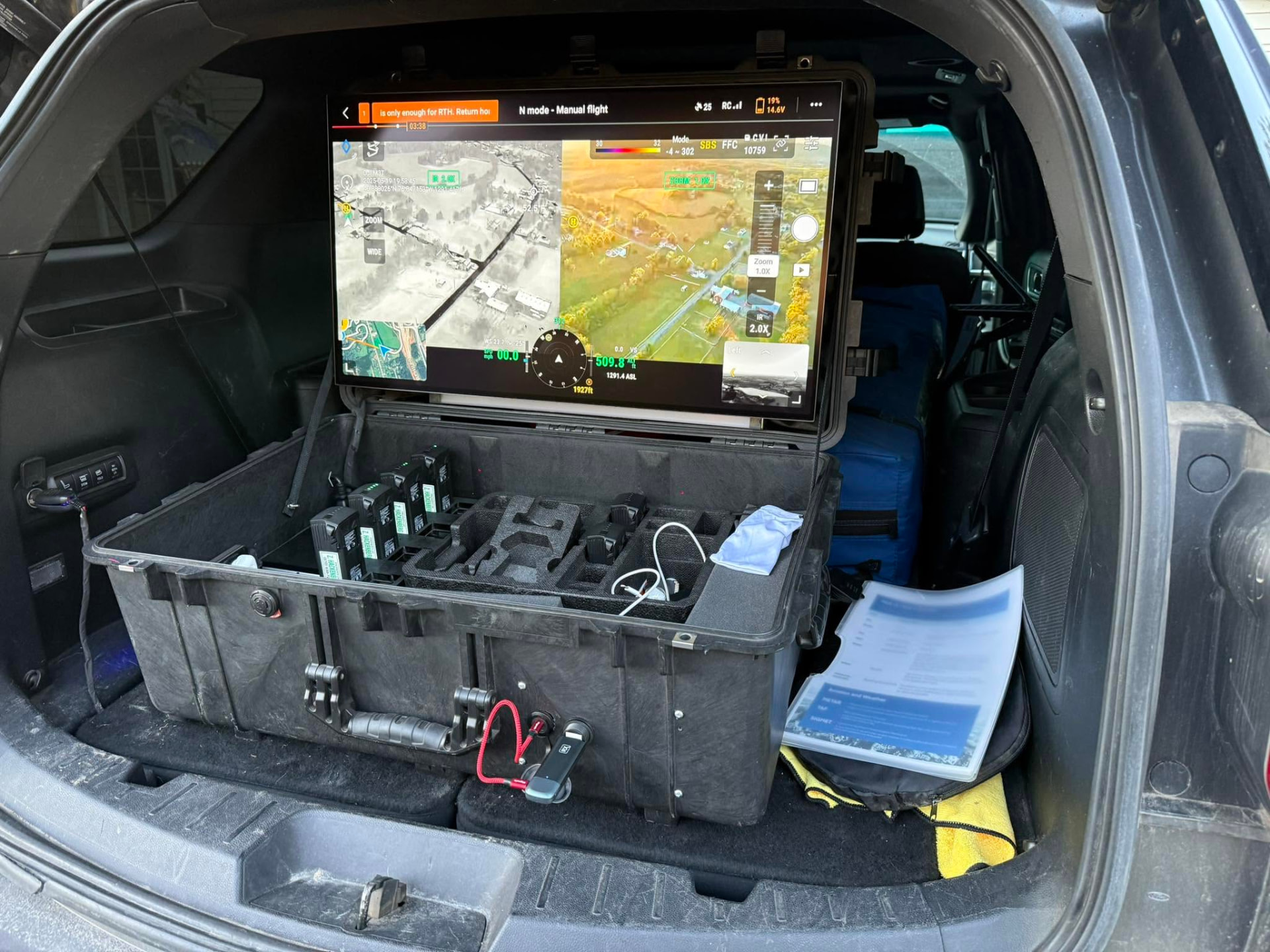 Drone ground station and battery case set up in the back of a vehicle showing thermal and visible camera feeds