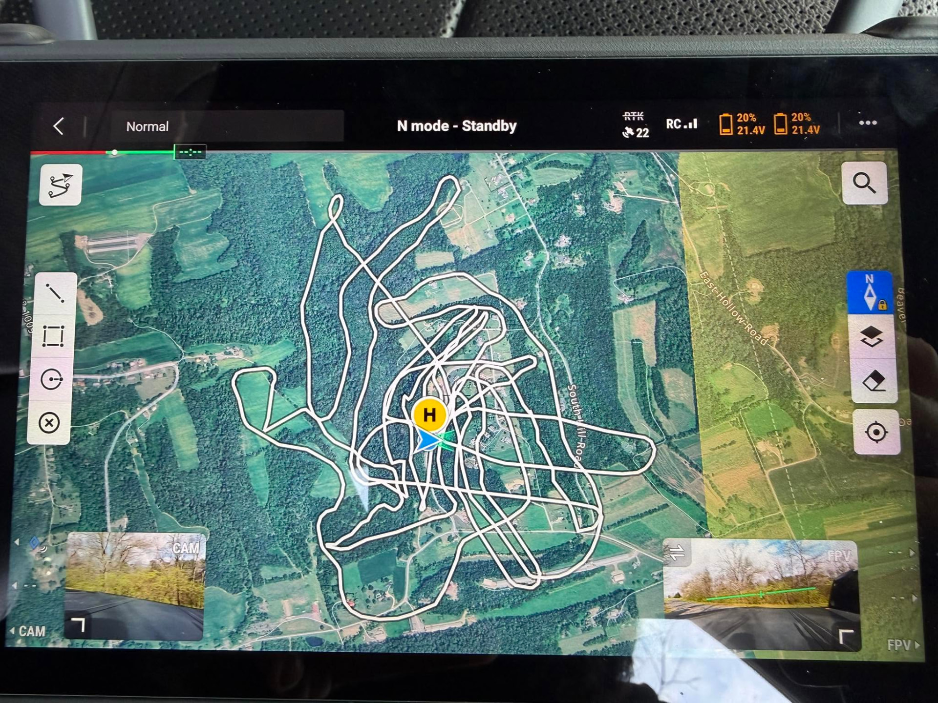 Drone controller showing a completed grid search flight path over farmland and forest
